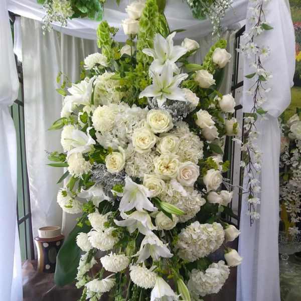 Tall white floral standing spray with lilies and roses