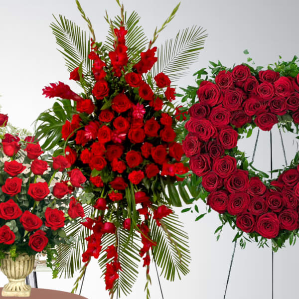 Set of red rose funeral pieces including casket spray, standing spray, vase bouquet, and heart wreath on easels