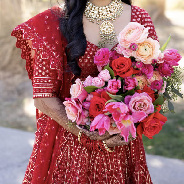 Woman in red dress holding a bouquet of pink and red flowers