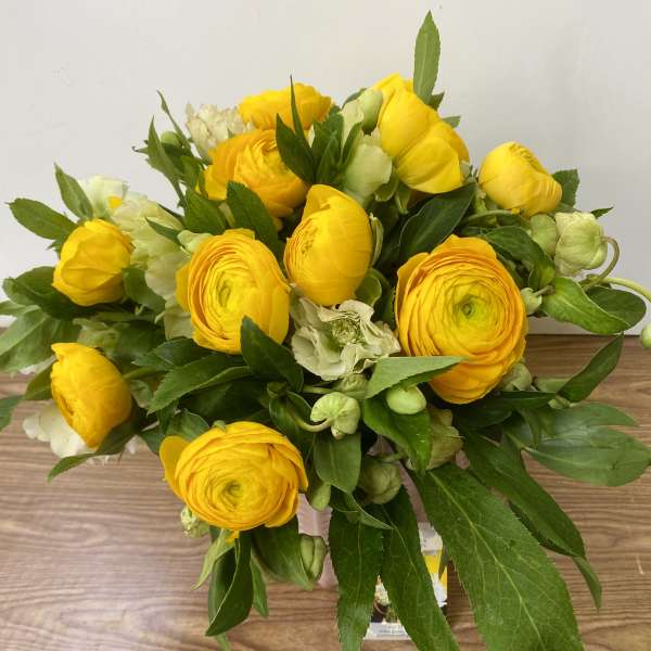 Yellow ranunculus bouquet with green foliage