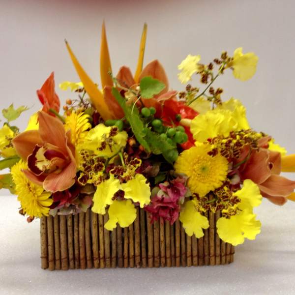 Bright yellow and orange floral arrangement in a rectangular wooden container