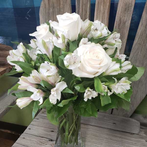 White roses and alstroemeria in a clear glass vase