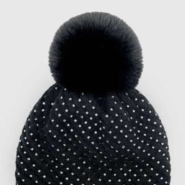 Black knit beanie with a pom-pom and small reflective square accents