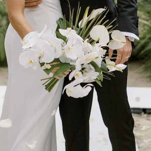 Bride and groom holding a white orchid wedding bouquet
