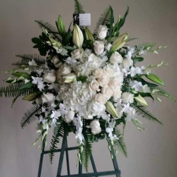 Large white floral standing spray on an easel