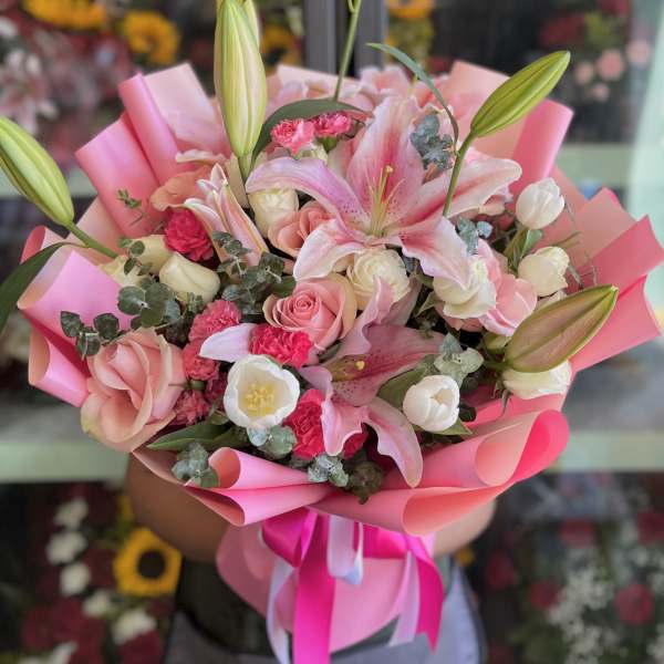 Pink and white bouquet with lilies and roses wrapped in pink paper