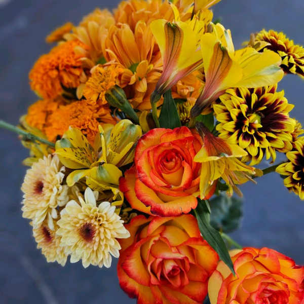 Bouquet of orange and yellow roses with mixed daisies and alstroemeria
