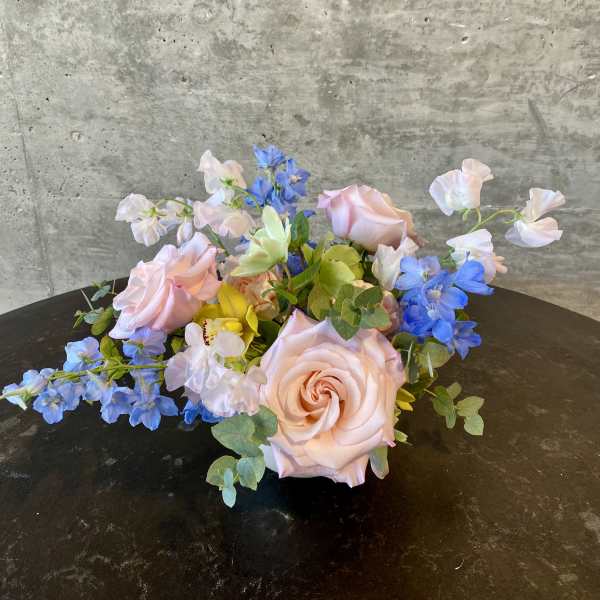 Low bouquet of pale pink roses with blue and white flowers