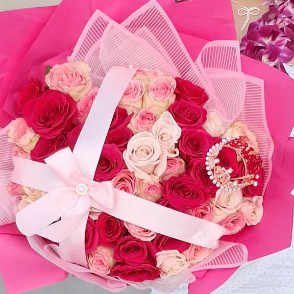 Bouquet of pink and red roses wrapped in bright pink paper