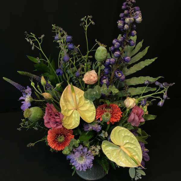 Mixed bouquet with purple, pink, and yellow flowers in a vase