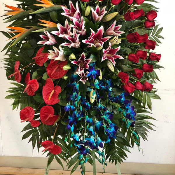 Large standing floral spray with red roses, lilies, and orchids