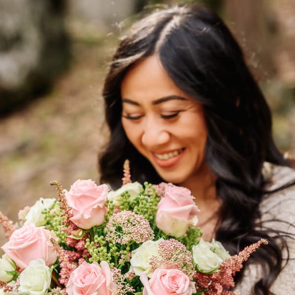 Woman holding a bouquet of pink and white roses