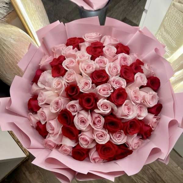 Bouquet of red and pale pink roses wrapped in pink paper