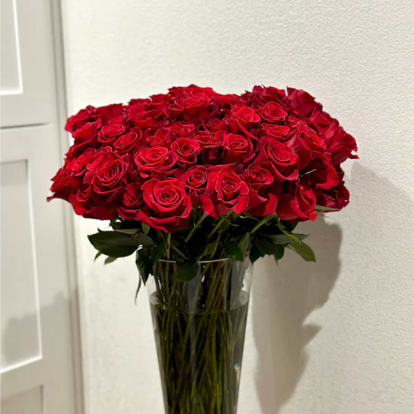Large bouquet of red roses in a tall clear glass vase
