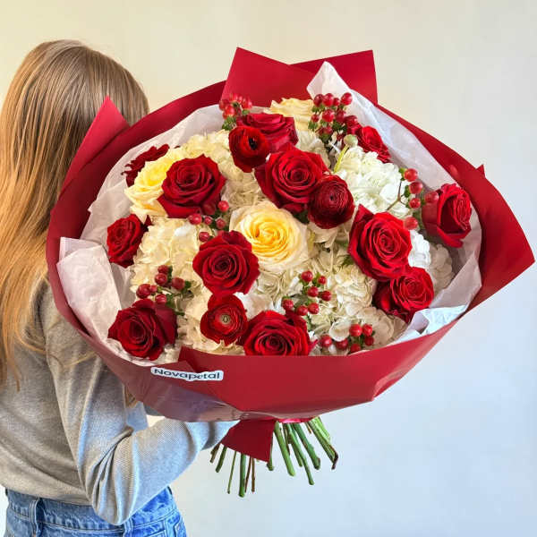 Large bouquet of red and cream roses wrapped in red paper