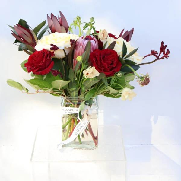 Bouquet of red and white flowers in a clear glass vase