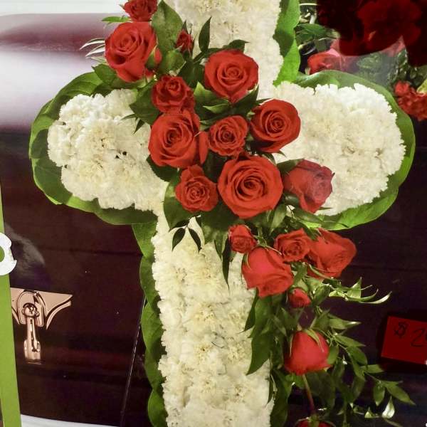 Cross-shaped floral arrangement with red roses and white carnations