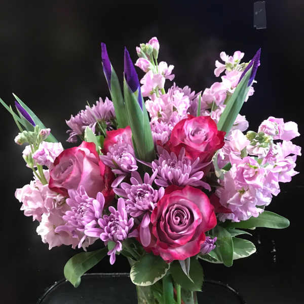 Pink and purple bouquet of roses and chrysanthemums in a glass vase