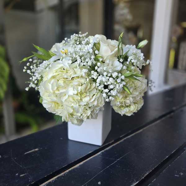 White hydrangea and rose bouquet in a white vase