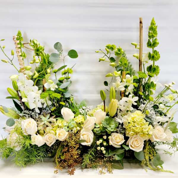 Large white and green floral arrangement with roses, lilies, and orchids