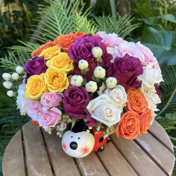 Colorful rose bouquet in a decorative bear-shaped container