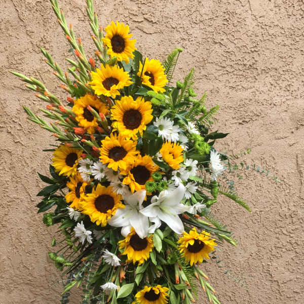 Tall floral spray with sunflowers, white lilies, and daisies
