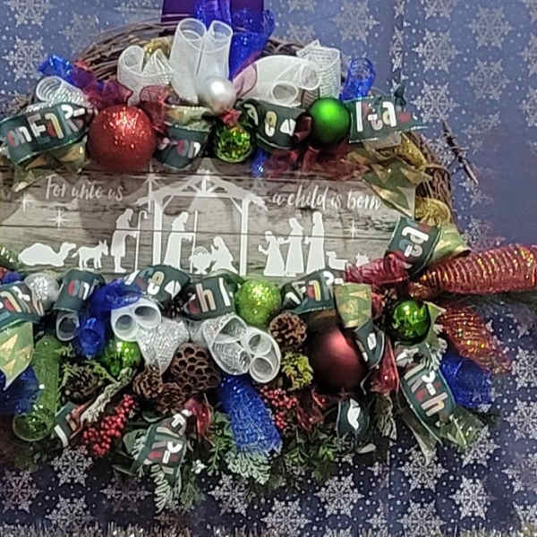 Christmas wreath with ribbon bows and ornaments around a wooden sign