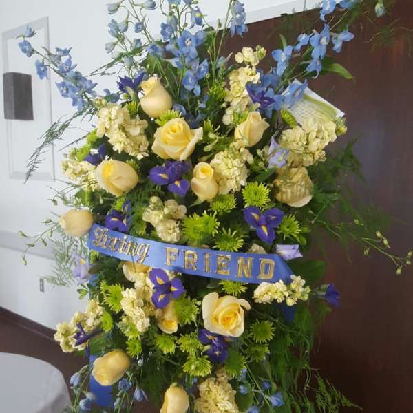 Tall floral standing spray with yellow roses and blue flowers