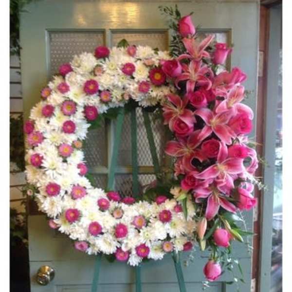Large floral wreath with pink lilies and white daisies on a door