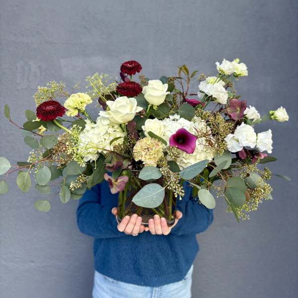 Mixed bouquet of white and burgundy flowers in a glass vase