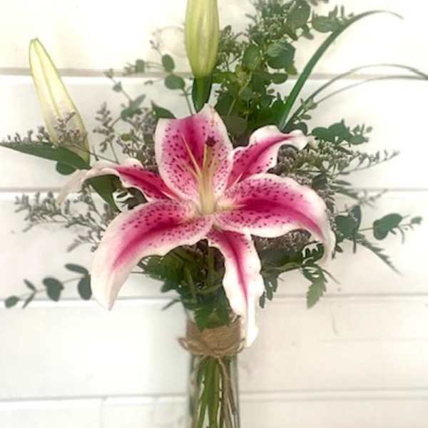 Pink stargazer lily bouquet in a tall glass vase