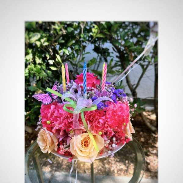 Bright mixed flower bouquet with candles and butterfly decorations