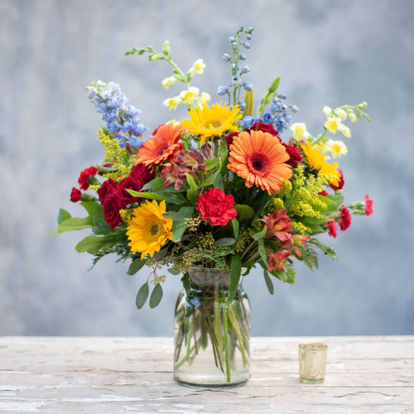Mixed bouquet of bright flowers in a clear glass vase