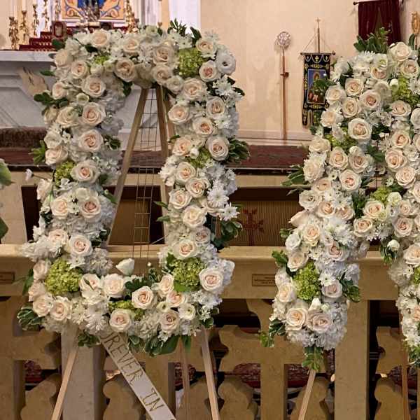 Tall standing floral letters spelling DAD in white and blush roses with green accents on easels.