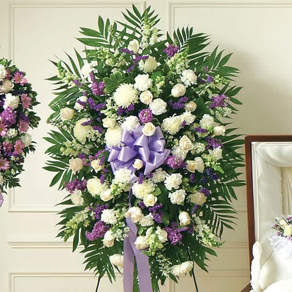 Standing floral spray with white and purple flowers and a lavender ribbon