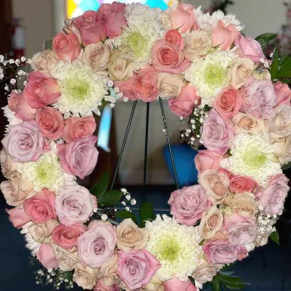 Heart-shaped arrangement of pink and cream roses with white chrysanthemums