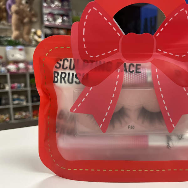 Red bow-shaped gift package with false eyelashes inside
