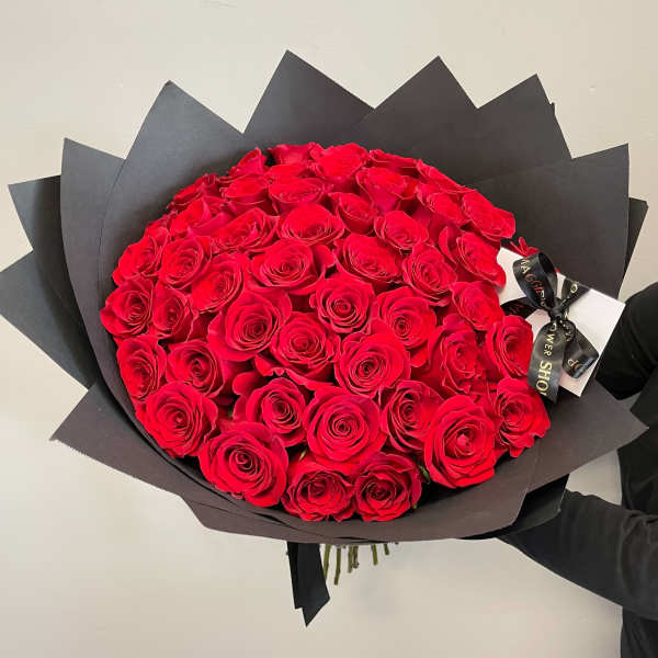 Large bouquet of red roses wrapped in black paper
