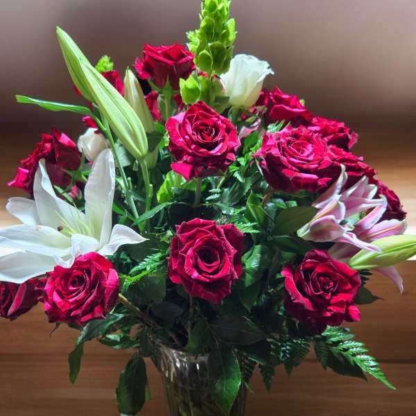 Bouquet of red roses and white lilies in a glass vase
