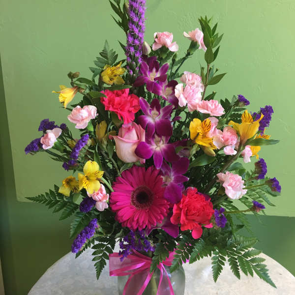 Mixed bouquet in a glass vase with pink, purple, and yellow flowers