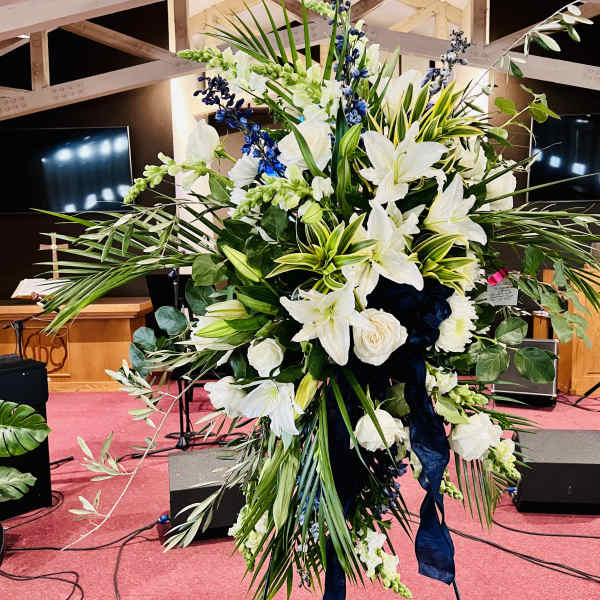 Large white and blue floral standing arrangement on an easel