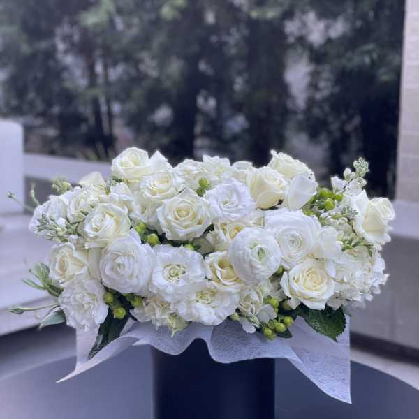 White rose and ranunculus arrangement in a black box