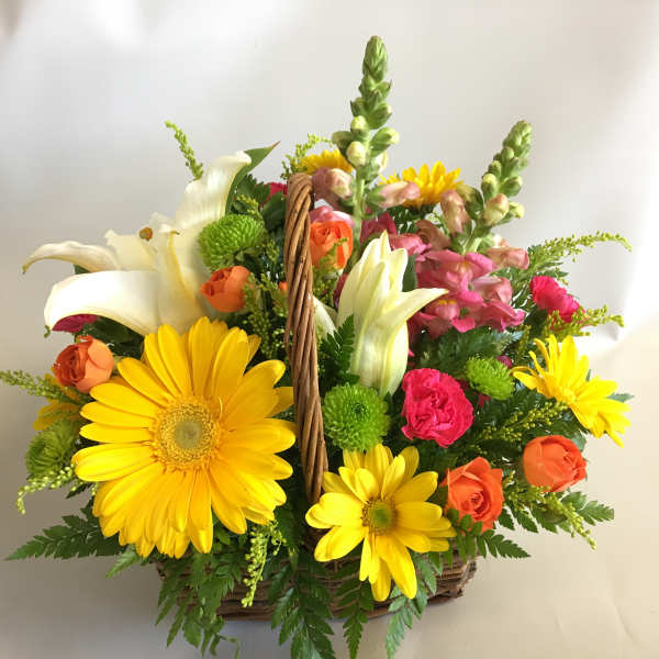 Basket arrangement with yellow daisies, white lilies, and pink and orange roses