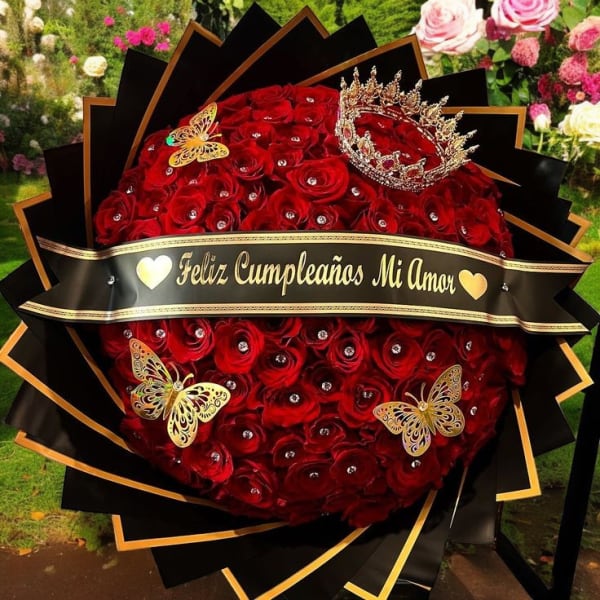 Large bouquet of red roses with a birthday banner and crown decorations