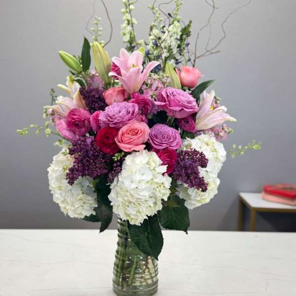 Pink and white mixed flower arrangement in a glass vase
