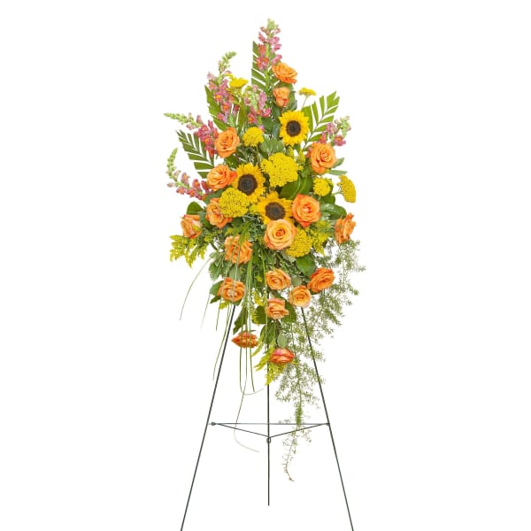 Tall standing spray of yellow sunflowers and orange roses with pink snapdragons on a metal easel