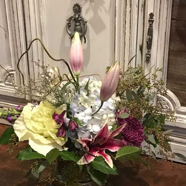 Mixed floral arrangement with lilies, hydrangea, and chrysanthemums in a vase