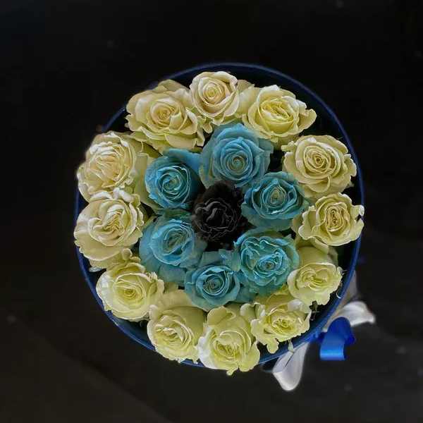 Round bouquet of pale yellow and blue roses with a ribbon wrap