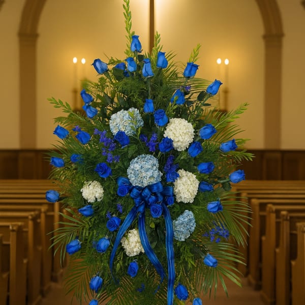 Blue rose funeral spray with white and pale blue flowers
