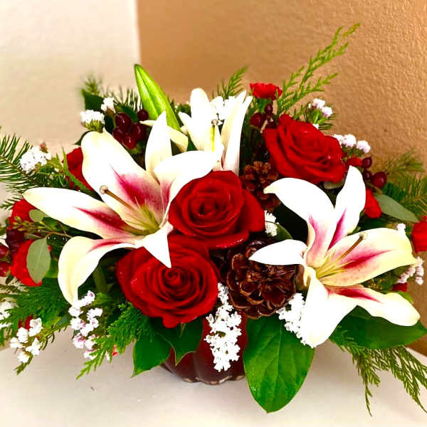 Red roses and white lilies arranged in a low vase